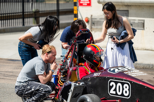 5 students on the Motorsports Team conduct test rides in an alley on MIT’s campus