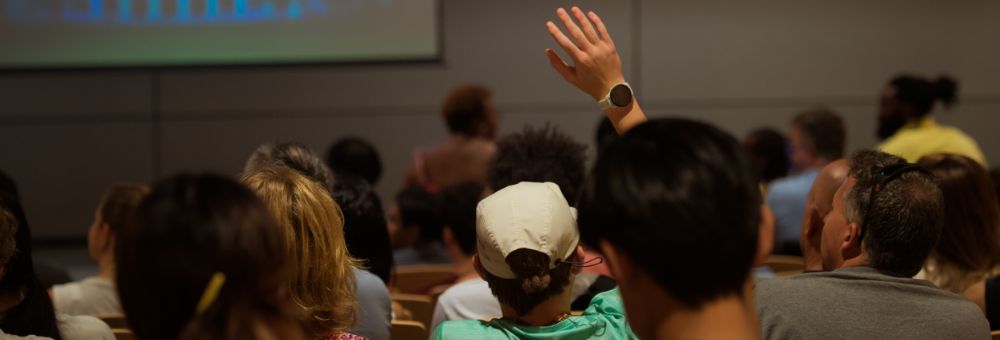 A student raises their hand in a classroom.